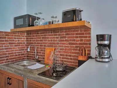 a kitchen with a sink and a brick wall at Mistral Studio Umalas in Canggu
