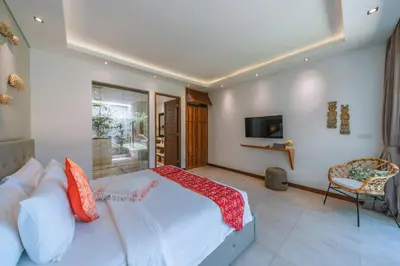 a bedroom with a large bed and a television at PROMO - 4 Bedroom Designer Villa 2 minutes to Berawa Beach & Finns in Canggu