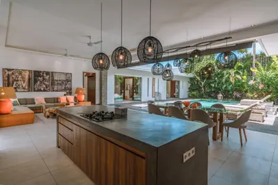 an open kitchen and living room with a table at PROMO - 4 Bedroom Designer Villa 2 minutes to Berawa Beach & Finns in Canggu