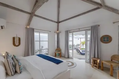 a bedroom with a white bed and a balcony at Villa Cocodrilos 2 by Pertama Management in Seminyak