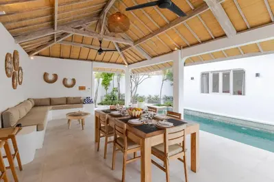 a dining room and living room with a table and chairs at Villa Cocodrilos 2 by Pertama Management in Seminyak