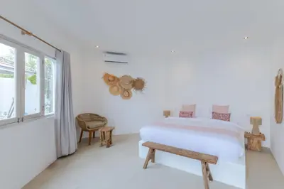 a white bedroom with a bed and a window at Villa Cocodrilos 2 by Pertama Management in Seminyak