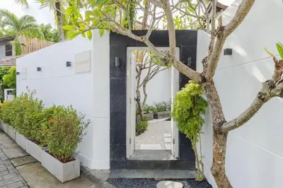 a white house with a black and white door at Villa Cocodrilos 2 by Pertama Management in Seminyak