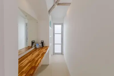 a hallway with white walls and wooden floors at Villa Cocodrilos 2 by Pertama Management in Seminyak