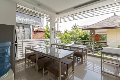 a dining room with tables and chairs on a balcony at AI Hotel Kuta - 15 Second to the Beach and 1 Minute to Airport by Micky Studio in Ngurah Rai International Airport