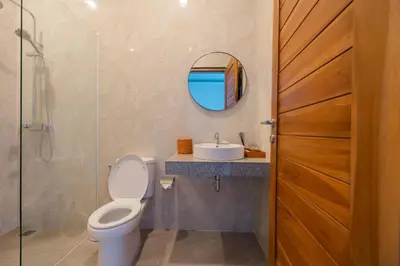 a bathroom with a toilet and a sink and a mirror at Arvi Villa Pandawa Legian in Legian