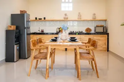 a kitchen with a wooden table and chairs at Alicia - Stylish 2BR Villa with Large Pool in Kerobokan
