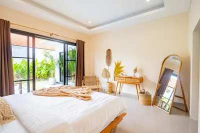 a bedroom with a bed and a mirror at Alicia - Stylish 2BR Villa with Large Pool in Kerobokan