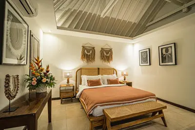 a bedroom with a bed and a table and flowers at Coral Heaven 1 by Bali Villa Solutions in Seminyak