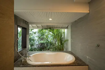 a bath tub in a bathroom with a window at Coral Heaven 1 by Bali Villa Solutions in Seminyak
