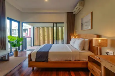 a bedroom with a large bed and a balcony at Villa Club Residence 8 by Maheswara in Canggu