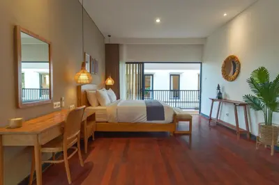 a bedroom with a bed and a desk and a table at Villa Club Residence 8 by Maheswara in Canggu