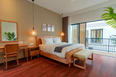 a bedroom with a bed and a desk and a balcony at Villa Club Residence 8 by Maheswara in Canggu