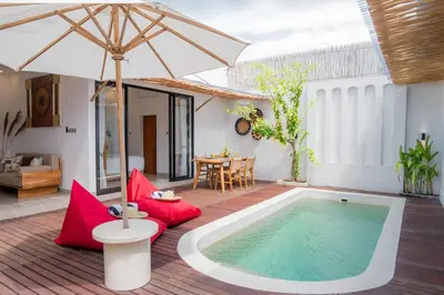 a patio with a swimming pool and an umbrella at Villa Grace a 2BR Retreat with private pool in Seminyak