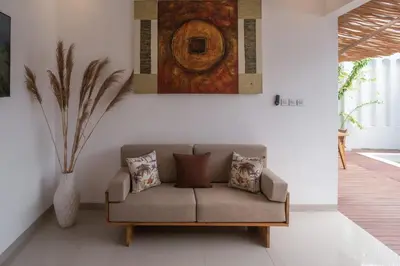 a couch in a living room with a painting on the wall at Villa Grace a 2BR Retreat with private pool in Seminyak