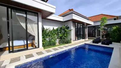 a villa with a swimming pool next to a house at Modern Tropical 2 Bedroom Villa Ocean Nest in Canggu