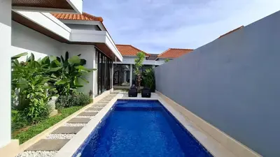 a swimming pool in front of a house at Modern Tropical 2 Bedroom Villa Ocean Nest in Canggu