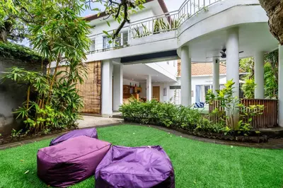 a garden with a purple lawn in front of a building at Beautiful villas - Right by the beach - Seminyak in Badung