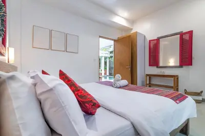a bedroom with two beds and red pillows at Beautiful villas - Right by the beach - Seminyak in Badung