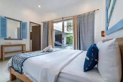 a bedroom with a large white bed with a window at Beautiful villas - Right by the beach - Seminyak in Badung