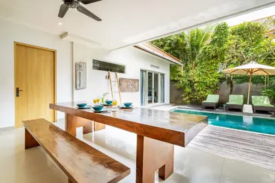 a dining room with a table and a swimming pool at Beautiful villas - Right by the beach - Seminyak in Badung