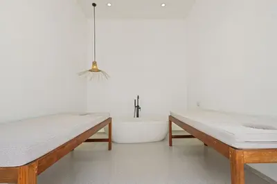 a white room with two benches and a bath tub at All-White Villa with Pool, Sauna, Firepit & Office in Jimbaran