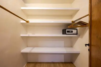 a walk in closet with white shelves and a lamp at Villa Camini - Newly Renovated Beautiful 2BR Family Villa 6px With Garden And Private Pool in Kerobokan