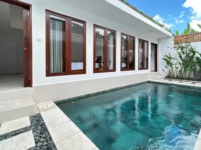 a swimming pool in front of a house at Mango Villa Seminyak in Kerobokan