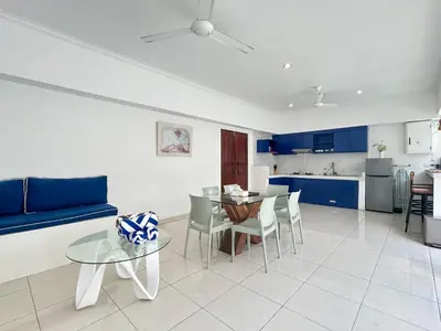 a living room with a table and a blue couch at Mango Villa Seminyak in Kerobokan