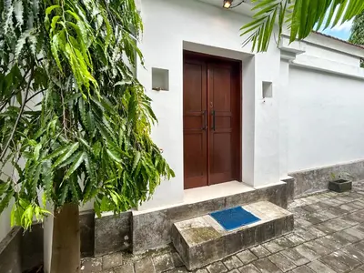 a house with a wooden door on the side of it at Mango Villa Seminyak in Kerobokan