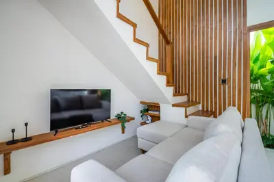 a living room with a white couch and a flat screen tv at Kuta Beach Villas by Great Bali Villas in Badung