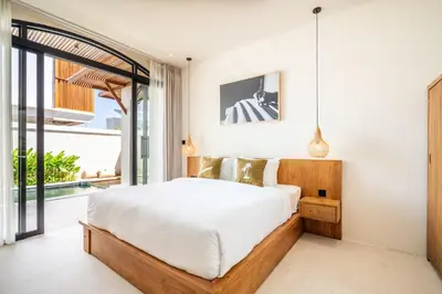 a bedroom with a bed and a large window at Kuta Beach Villas by Great Bali Villas in Badung