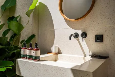 three bottles of wine sitting on a bathroom sink at Kuta Beach Villas by Great Bali Villas in Badung