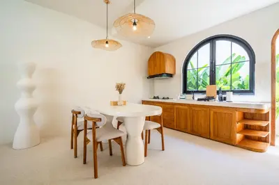 a kitchen with a table and chairs and a sink at Kuta Beach Villas by Great Bali Villas in Badung