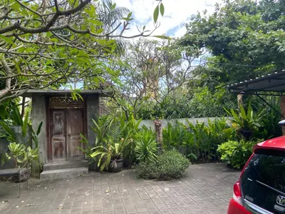 a house with a wooden door in a garden at P Hotel Kuta-3minutes to the beach by Micky Studio in Legian