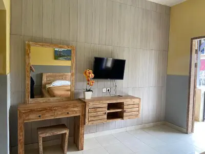 a room with a mirror and a television on a dresser at P Hotel Kuta-3minutes to the beach by Micky Studio in Legian