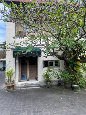 a building with a tree in front of it at P Hotel Kuta-3minutes to the beach by Micky Studio in Legian