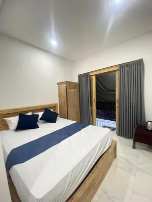 a bedroom with a large bed with blue pillows at SH Hotel Kuta- 20 Second to the Beach by Micky Studio in Legian