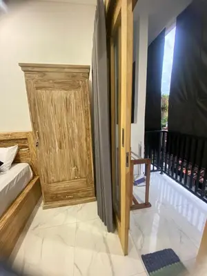 a room with a wooden door and a bed at SH Hotel Kuta- 20 Second to the Beach by Micky Studio in Legian