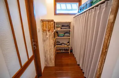 a hallway with a closet with white blinds at The Sundara Room in Kerobokan