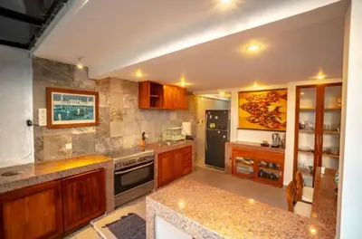 a kitchen with wooden cabinets and a stove top oven at The Sundara Room in Kerobokan