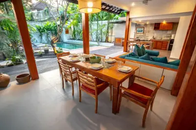 a dining room with a wooden table and chairs at The Sundara Room in Kerobokan
