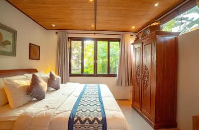 a bedroom with a large bed and a window at The Padma Room in Kerobokan
