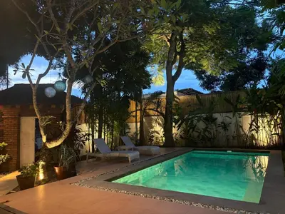 a swimming pool in a yard with trees at The Padma Room in Kerobokan