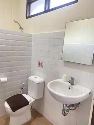 a white bathroom with a toilet and a sink at SH Hotel - 20 Second to the Bach by Micky Studio R in Legian