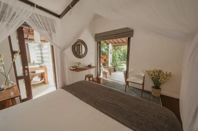 a bedroom with a large bed and a window at Villa Delapan Seminyak in Seminyak