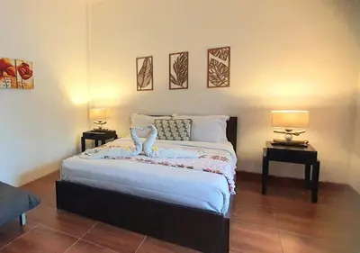 a bedroom with a bed with two tables and two lamps at Villa TJ Subali 3 BR privatepool close to Seminyak in Seminyak