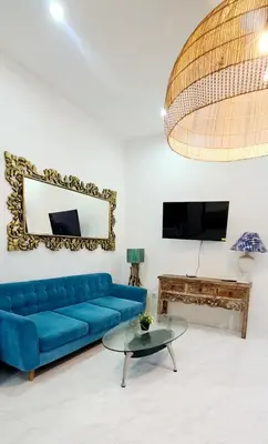 a living room with a blue couch and a table at Villa TJ Subali 3 BR privatepool close to Seminyak in Seminyak