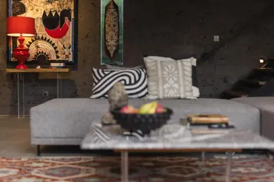 a living room with a couch and a bowl of fruit on a table at DUNE Villas in Seminyak