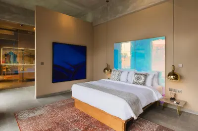 a bedroom with a large bed and a large painting on the wall at DUNE Villas in Seminyak